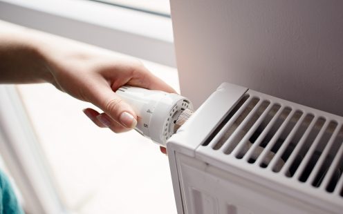 Closeup on woman's hand adjusting thermostat valve